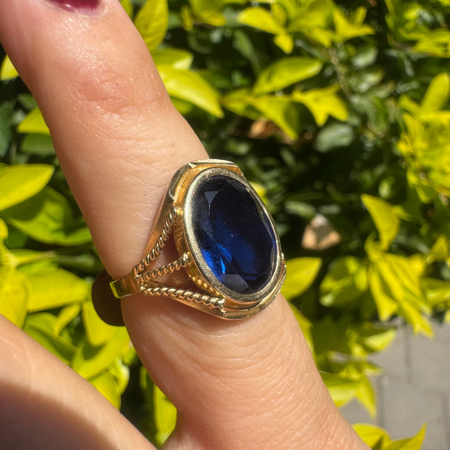 18K yellow gold ring set with a large oval deep blue Sapphire set in an ornate bezel.