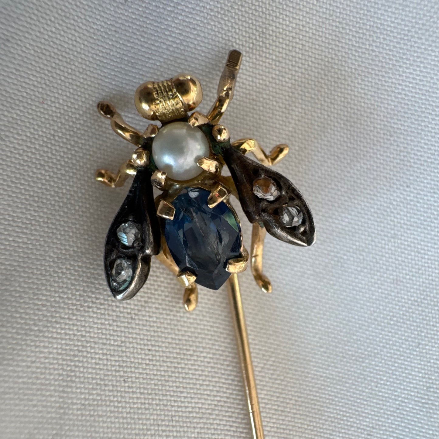14K gold insect stick pin set with sapphire, seed pearl, and small diamonds.