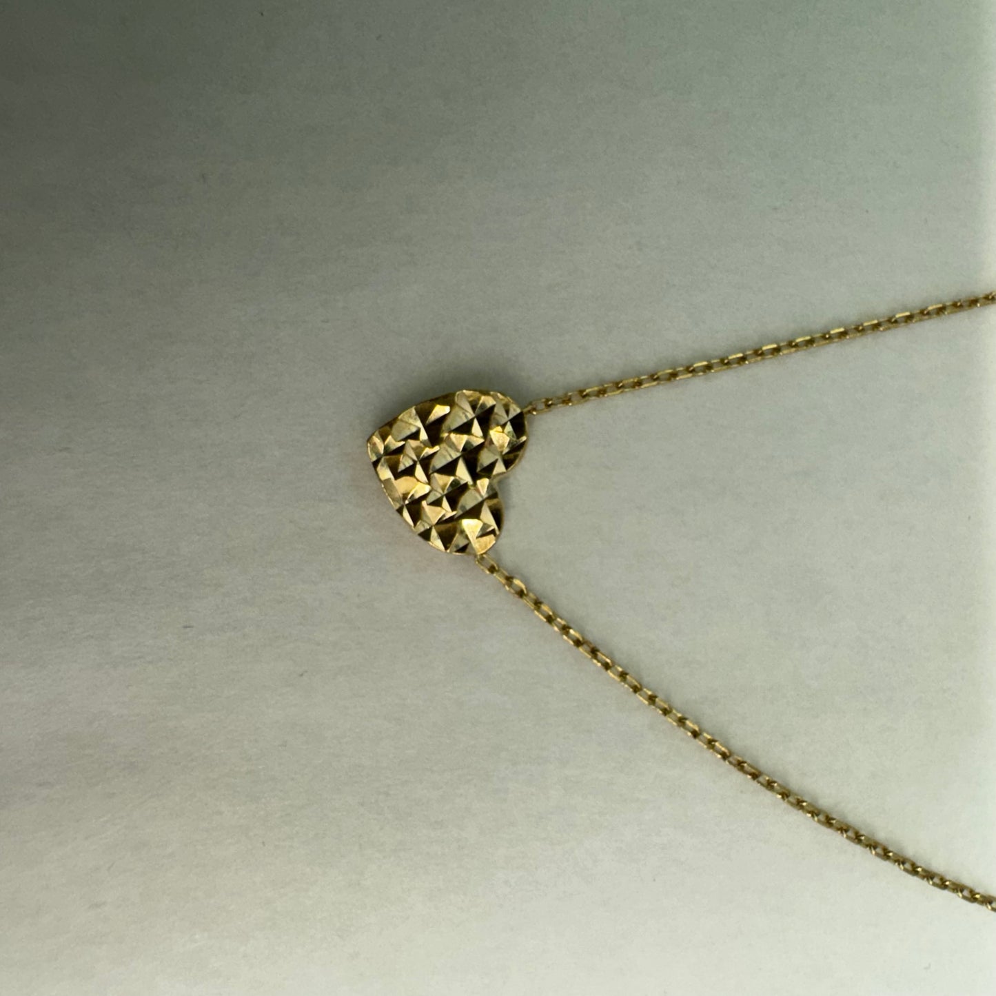 14K gold necklace featuring a heart-shaped pendant with a delicate geometric texture