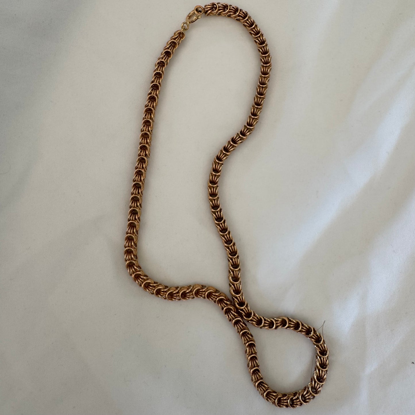 14K gold necklace featuring intricate, interwoven links that create a rich and textured look.