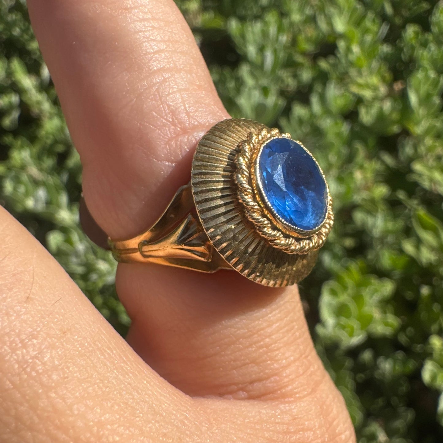 18K gold ring featuring a vibrant round Blue Topaz set in a textured gold bezel.