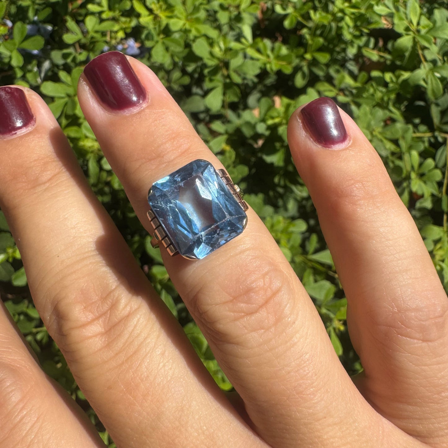 18K gold ring featuring a large rectangular Blue Topaz in a bezel setting with decorative side details.