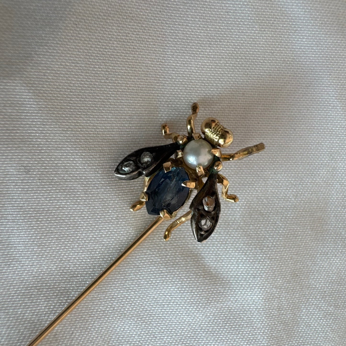 14K gold insect stick pin set with sapphire, seed pearl, and small diamonds.