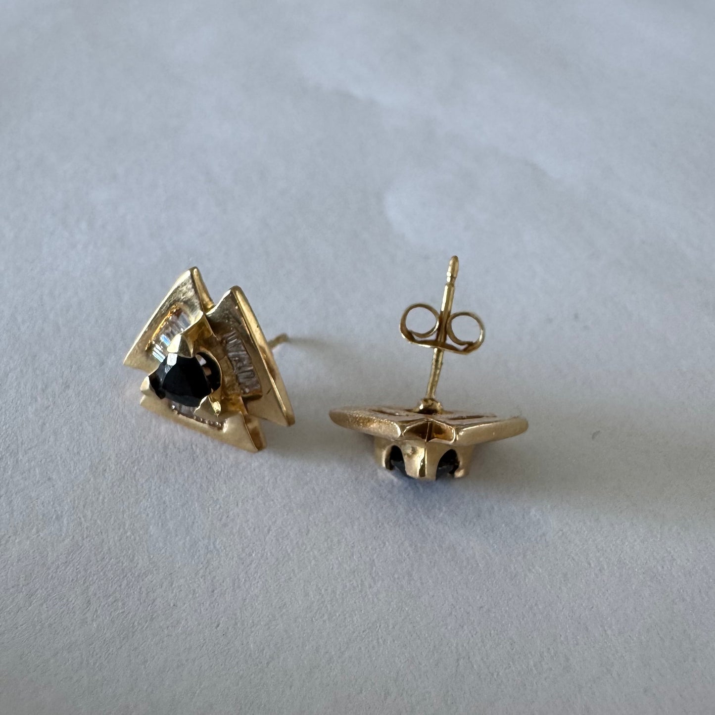14K gold geometric stud earrings set with a Sapphire stone, surrounded by baguette Diamonds.