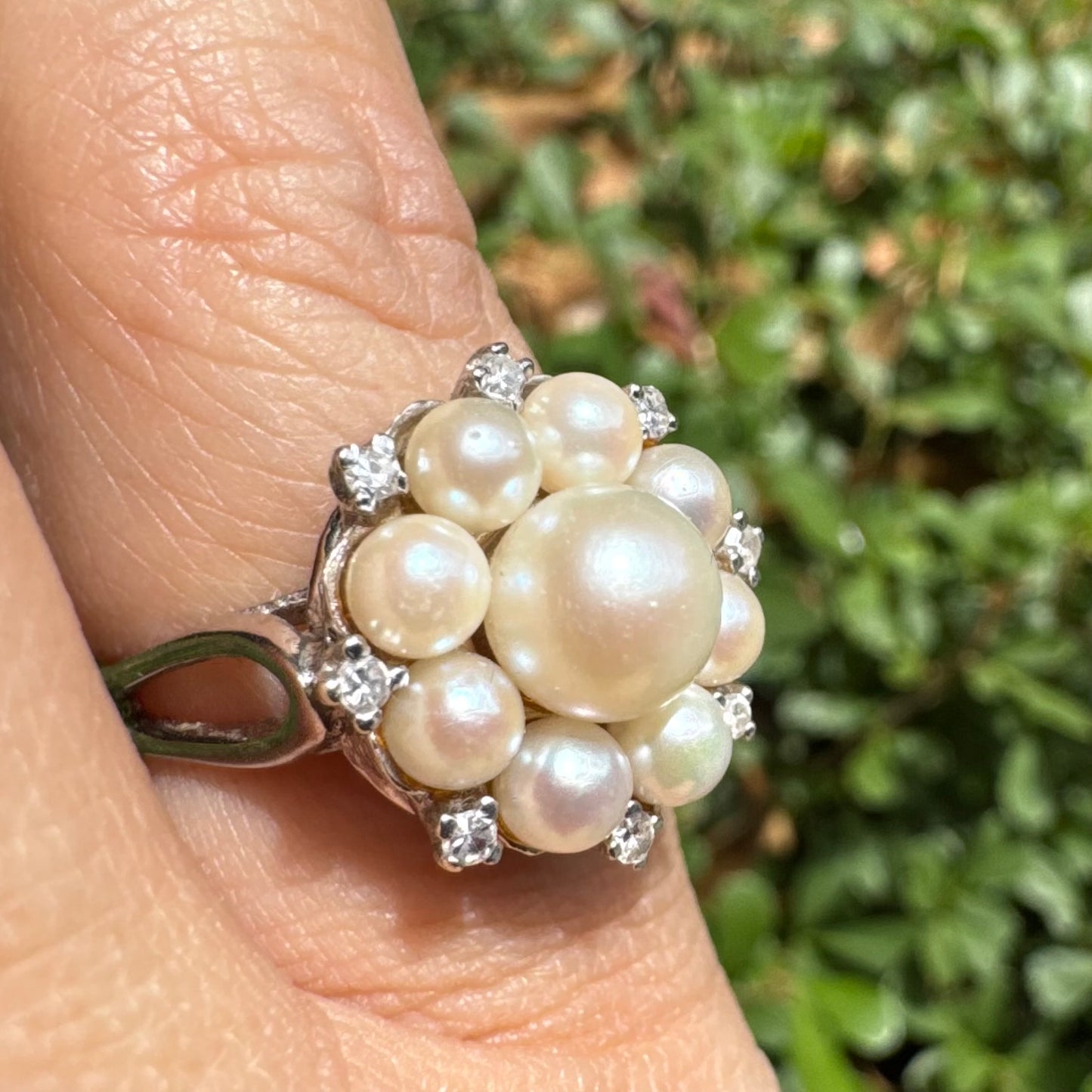 14K gold ring set with a floral cluster of lustrous Pearls in varying sizes, crowned by a central Pearl & surrounded by sparkling Diamond-like accents