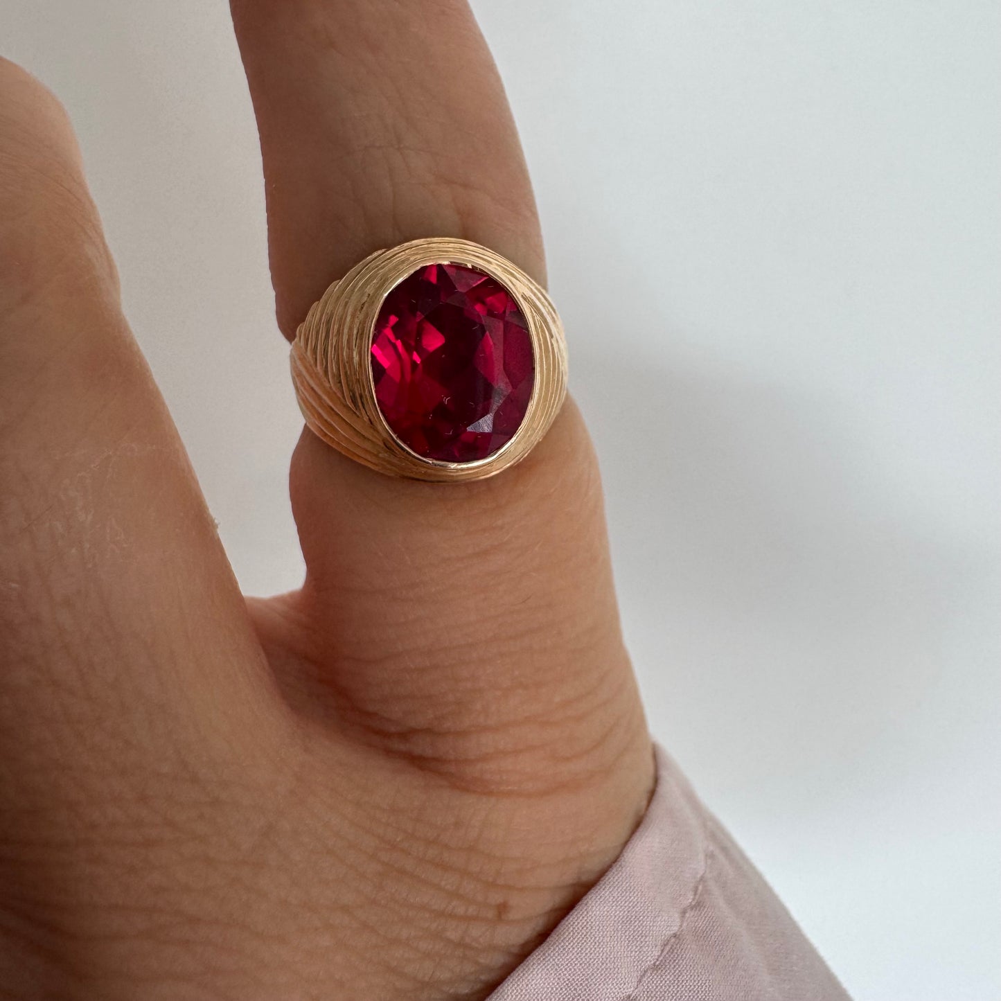 18K gold ring set with a striking oval-cut Ruby gemstone.