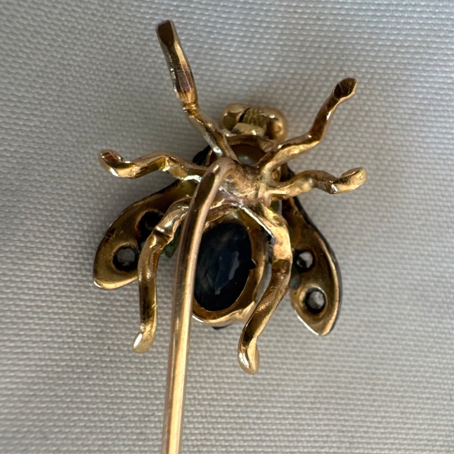 14K gold insect stick pin set with sapphire, seed pearl, and small diamonds.
