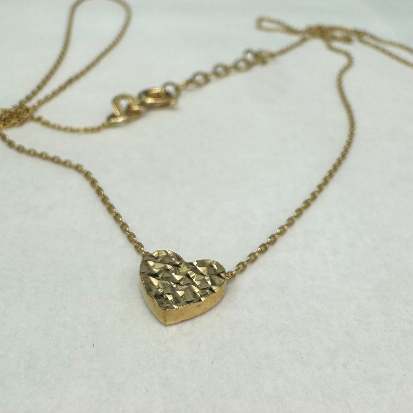 14K gold necklace featuring a heart-shaped pendant with a delicate geometric texture