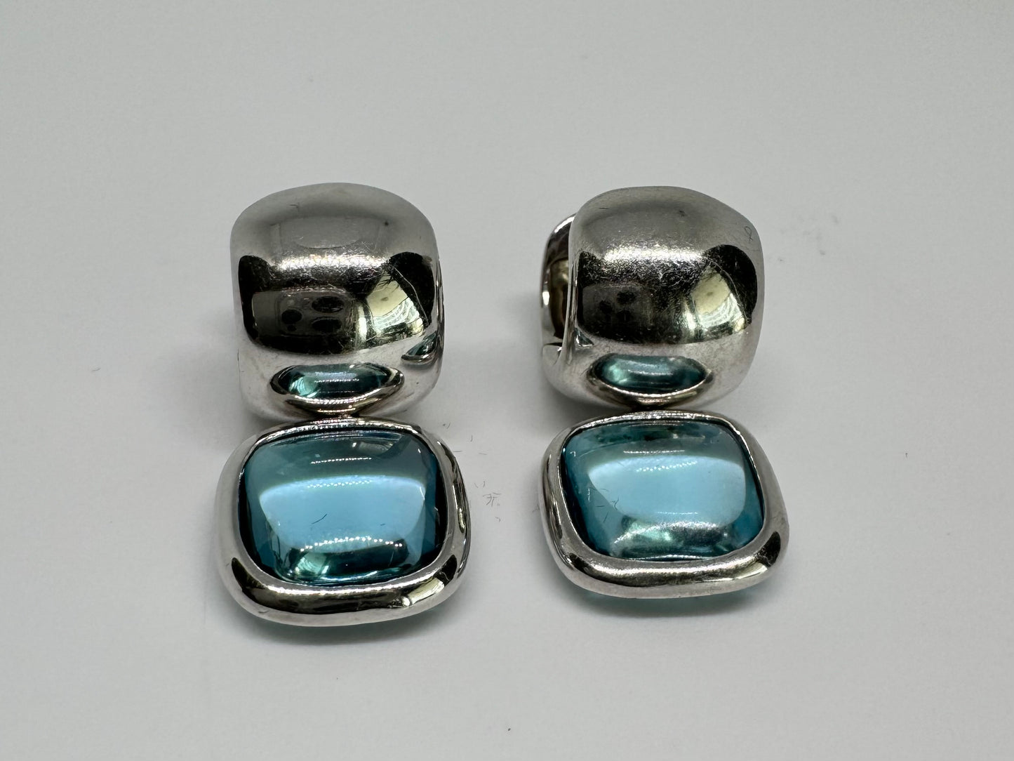 18K gold drop earrings featuring cushion-shaped Aquamarine in a smooth bezel setting, with a polished, modern design.