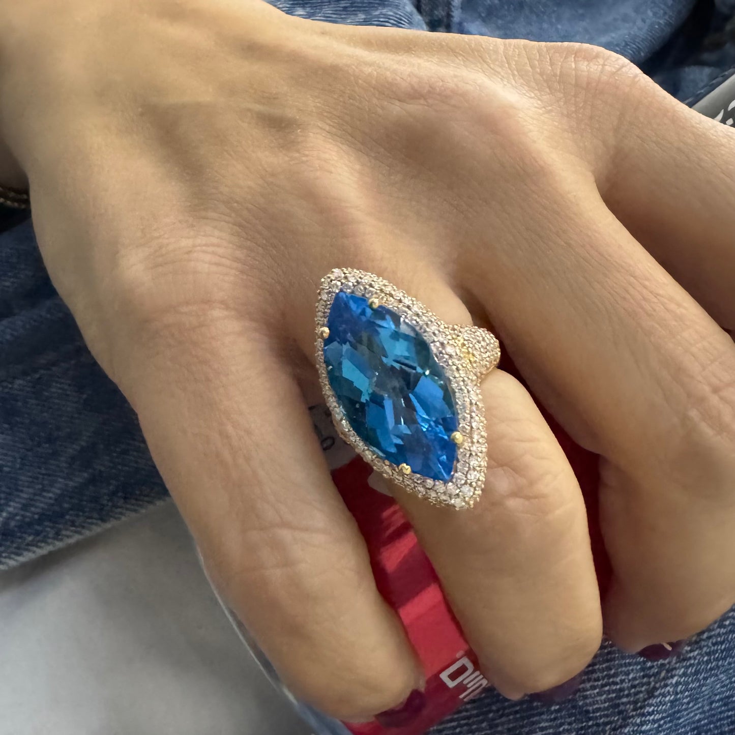 18K gold ring set with a large marquise-cut Blue Topaz gemstone, surrounded by sparkling Diamonds