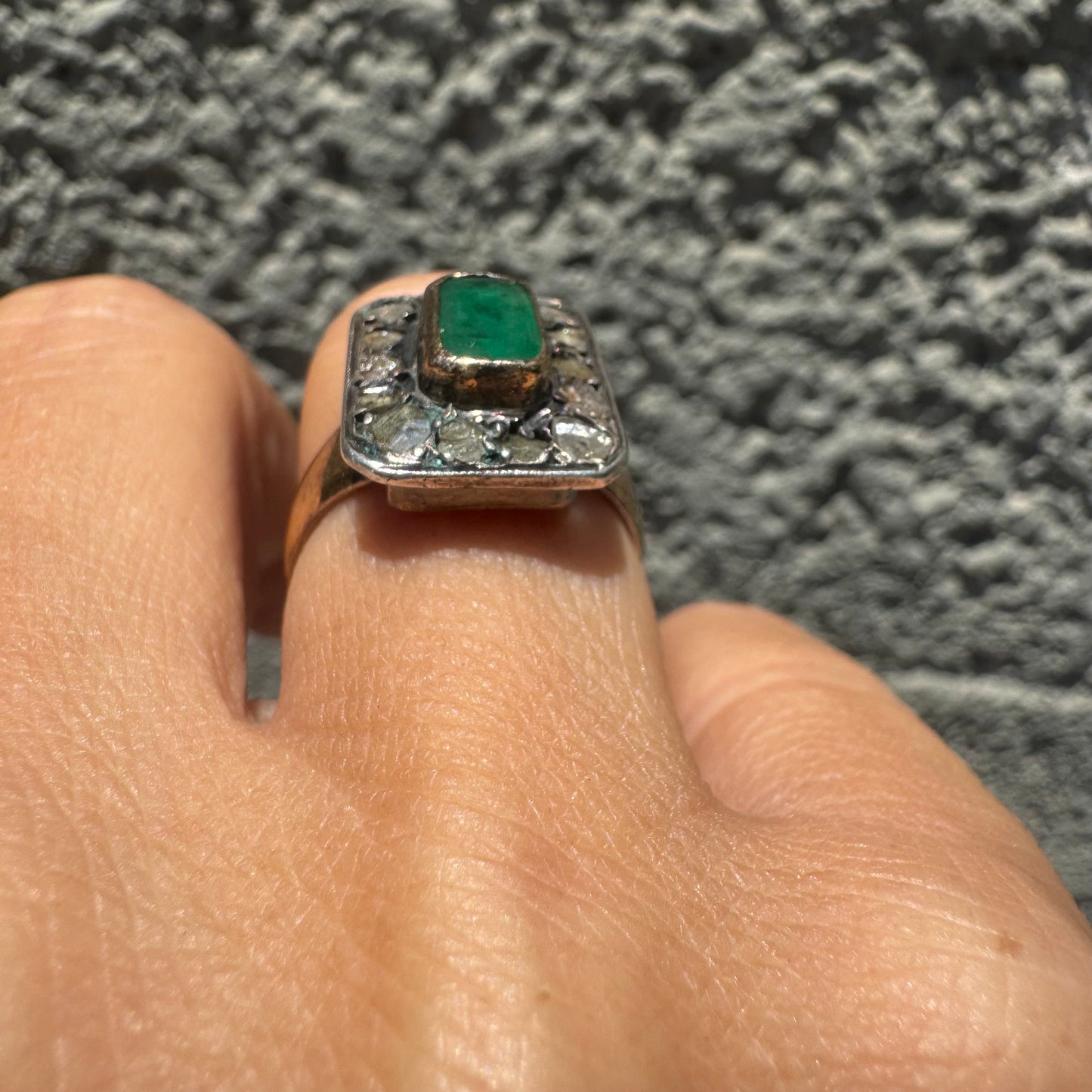 18K gold ring set with a rectangular Emerald and framed by a halo of rose-cut Diamonds