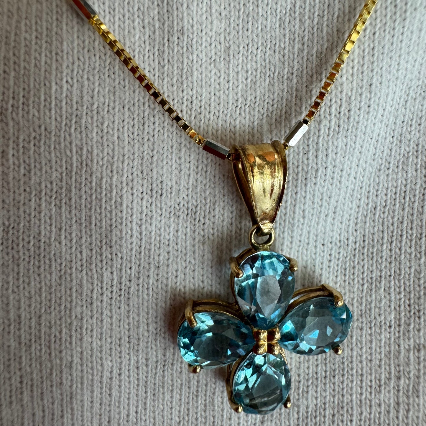 14K gold necklace with a cheerful floral pendant crafted from four pear-shaped Blue Topaz gemstones, arranged in a radiant blossom design