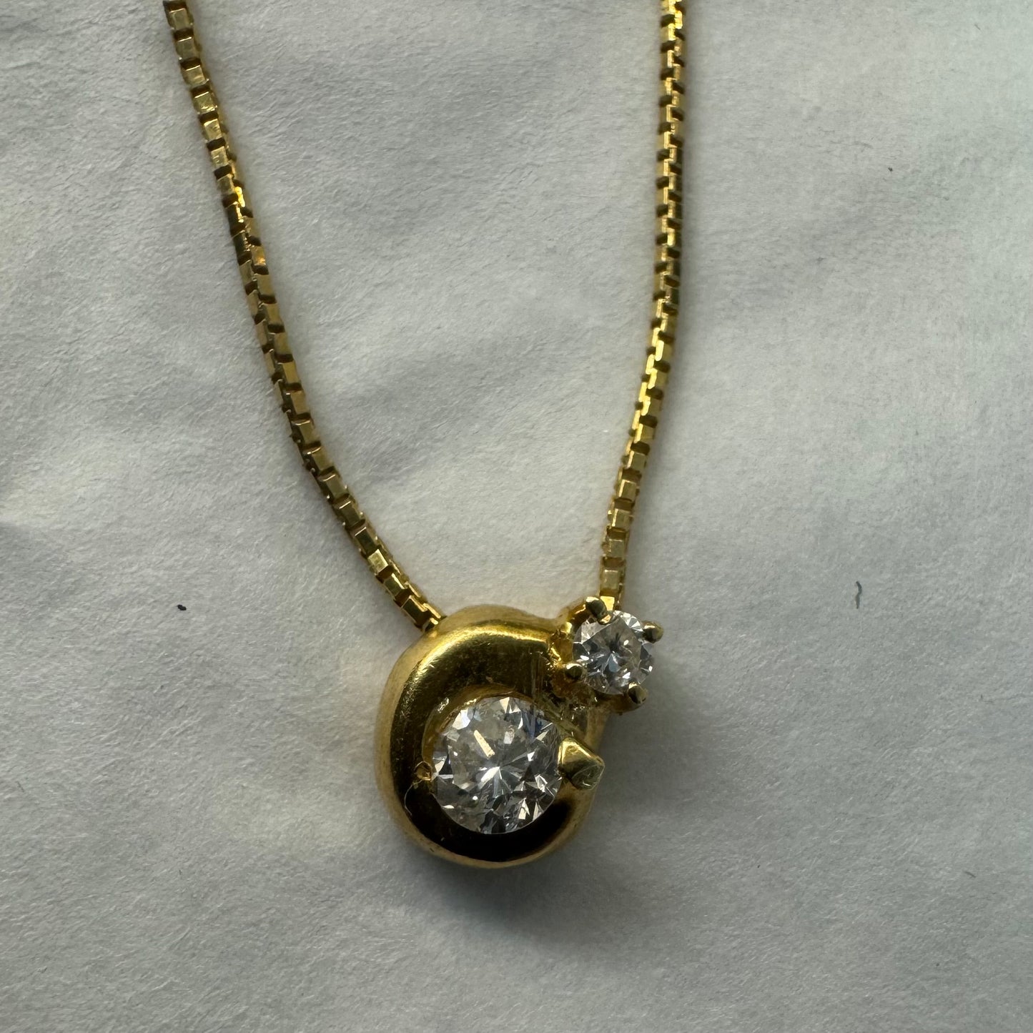 18K gold necklace set with a modern round pendant set with two brilliant-cut Diamonds in different sizes