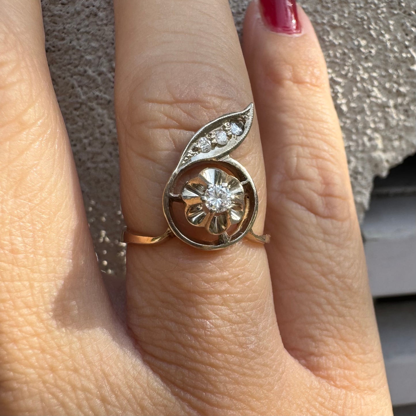 טבעת זהב צהוב 14 קראט בעיצוב פרח עדין המשובצת יהלומים נוצצים .