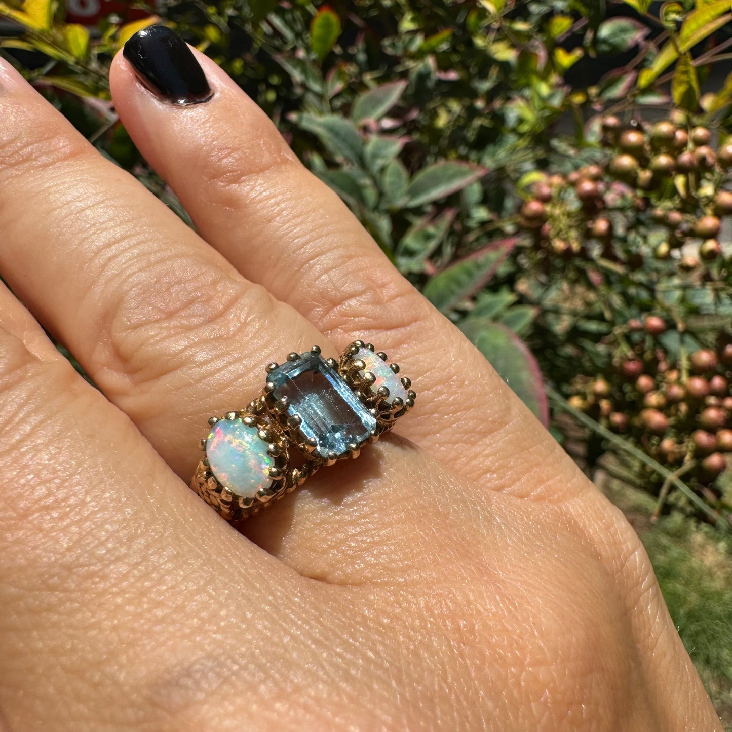 10K gold ring set with a light blue Aquamarine flanked by two dreamy Opals
