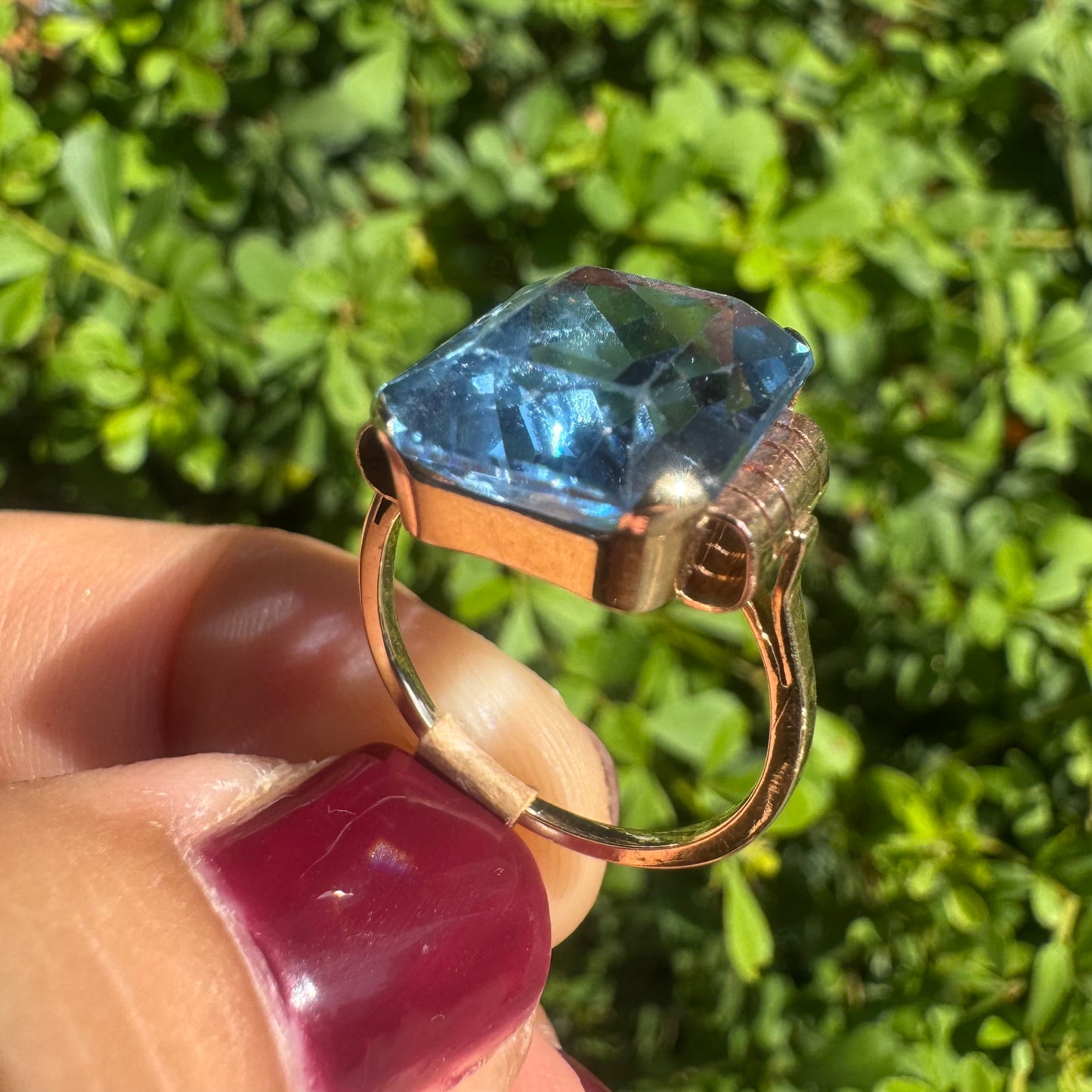 18K gold ring featuring a large rectangular Blue Topaz in a bezel setting with decorative side details.