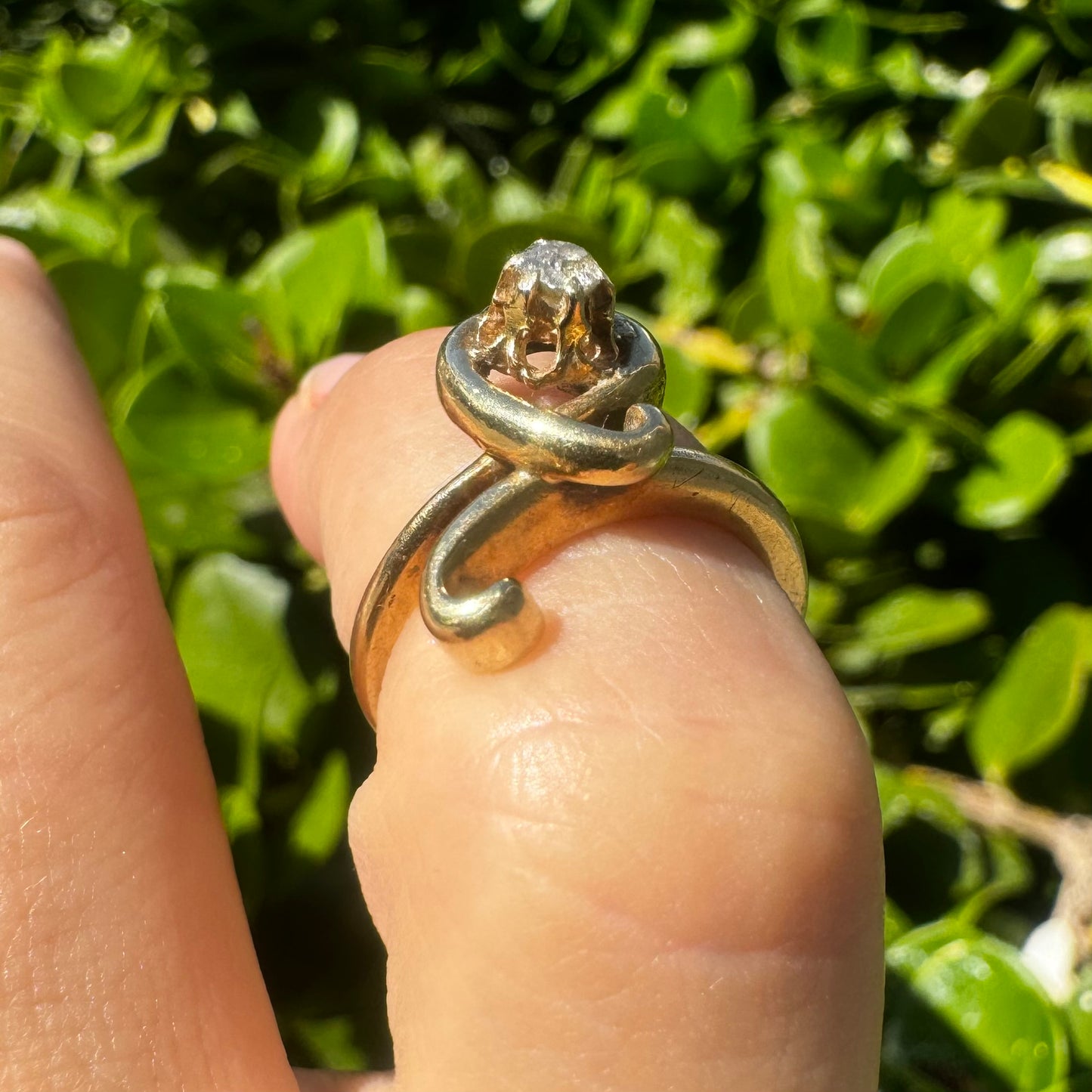 טבעת זהב צהוב 14 קראט משובצת יהלום מרכזי בעיצוב פיסולי וזורם.