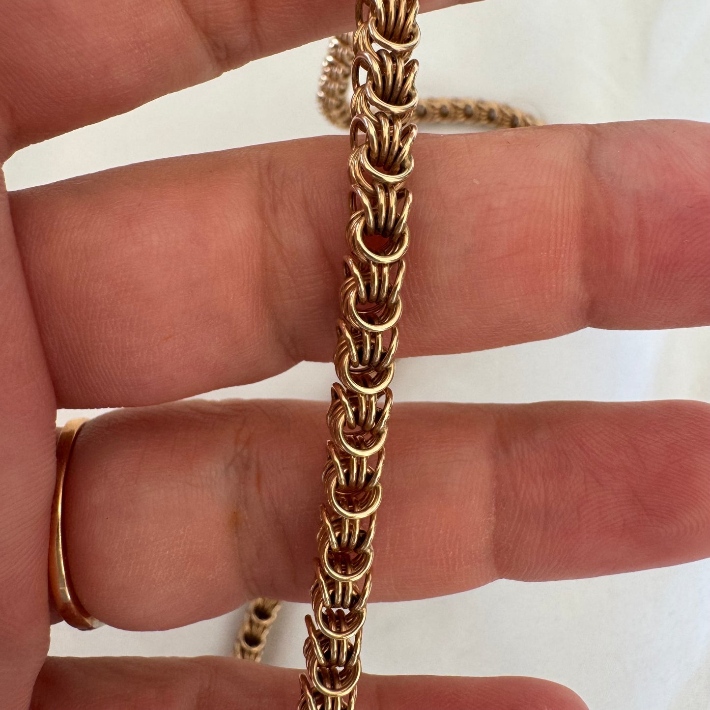 14K gold necklace featuring intricate, interwoven links that create a rich and textured look.