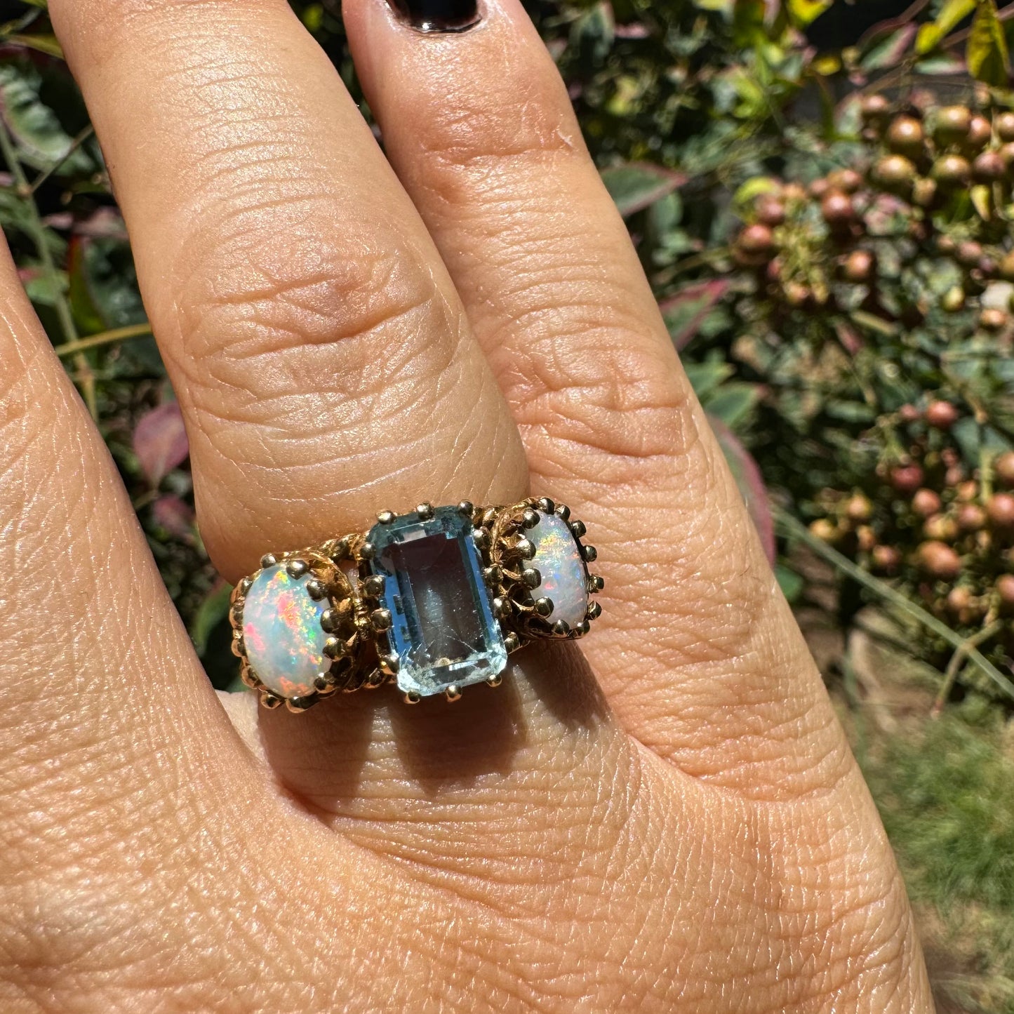10K gold ring set with a light blue Aquamarine flanked by two dreamy Opals