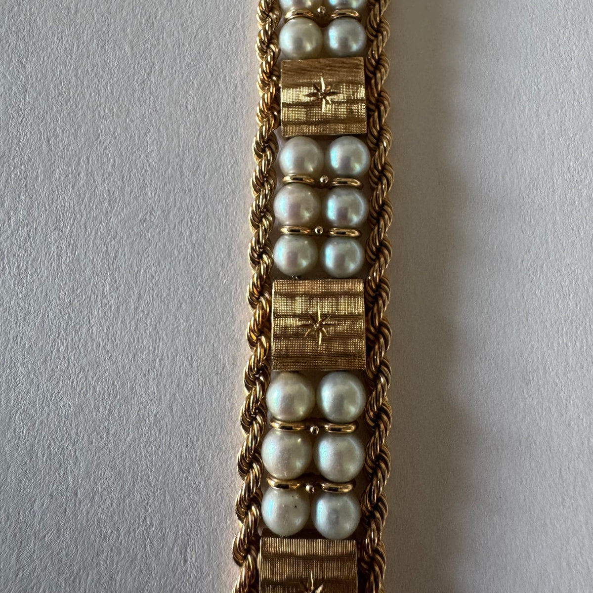14K gold bracelet set with Pearls, featuring intricate rope-style detailing and textured geometric gold elements.