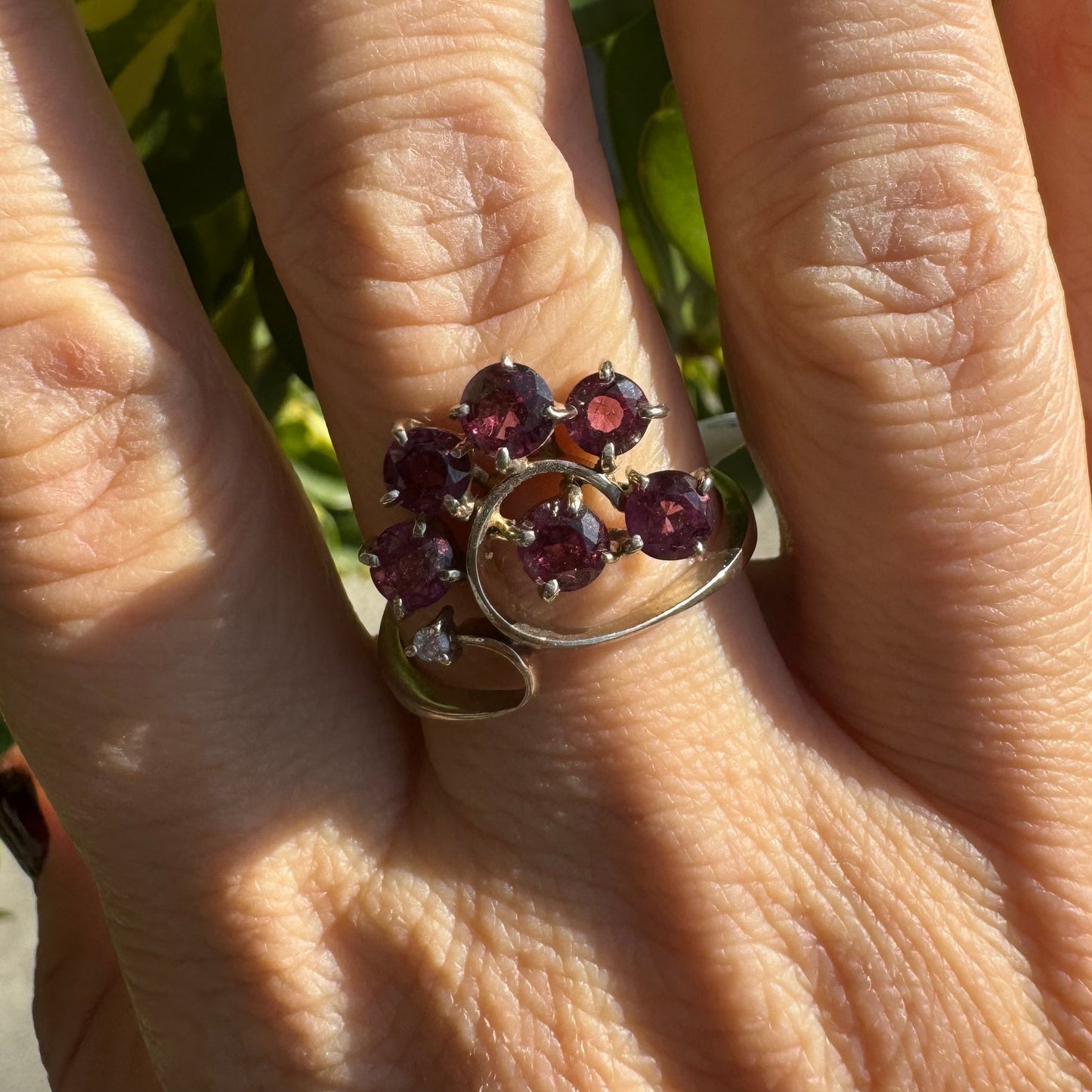 14K gold ring with an open, flowing design, set with multiple pink Tourmaline stones and accented by a Diamond