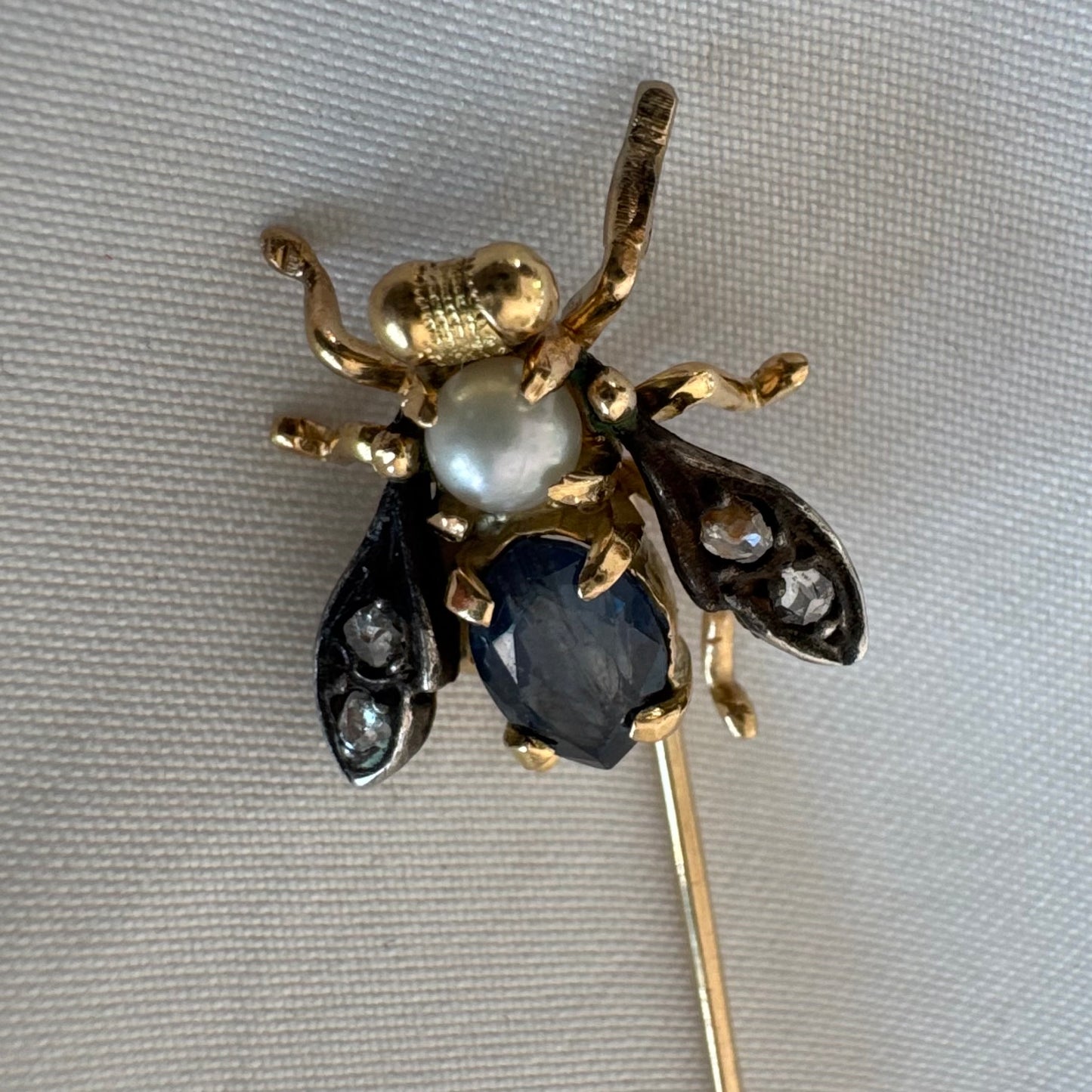14K gold insect stick pin set with sapphire, seed pearl, and small diamonds.