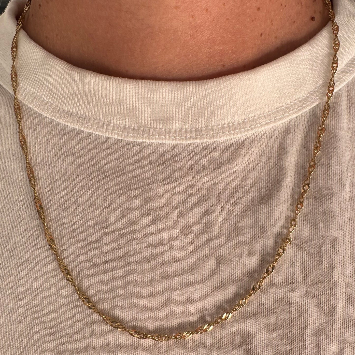 שרשרת זהב צהוב 14 קראט בעיצוב חוליות מסובבות ועדינות שמעניקות לה ברק ותנועה.