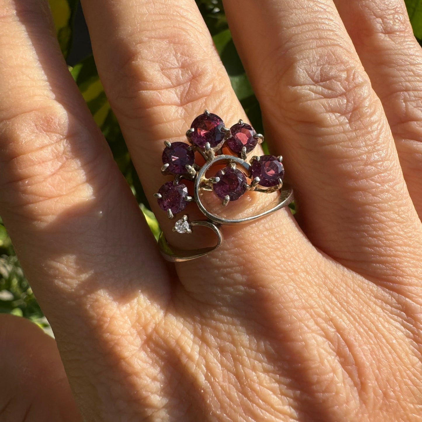 14K gold ring with an open, flowing design, set with multiple pink Tourmaline stones and accented by a Diamond