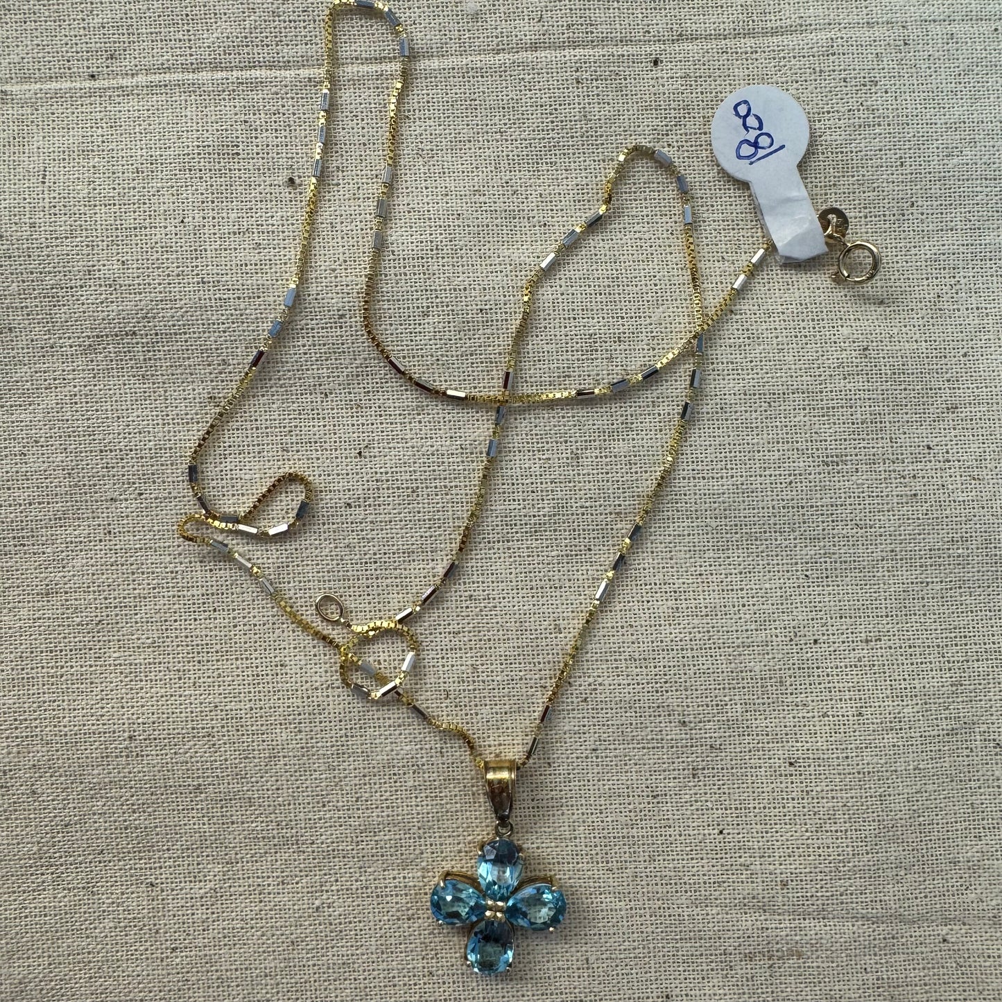 14K gold necklace with a cheerful floral pendant crafted from four pear-shaped Blue Topaz gemstones, arranged in a radiant blossom design