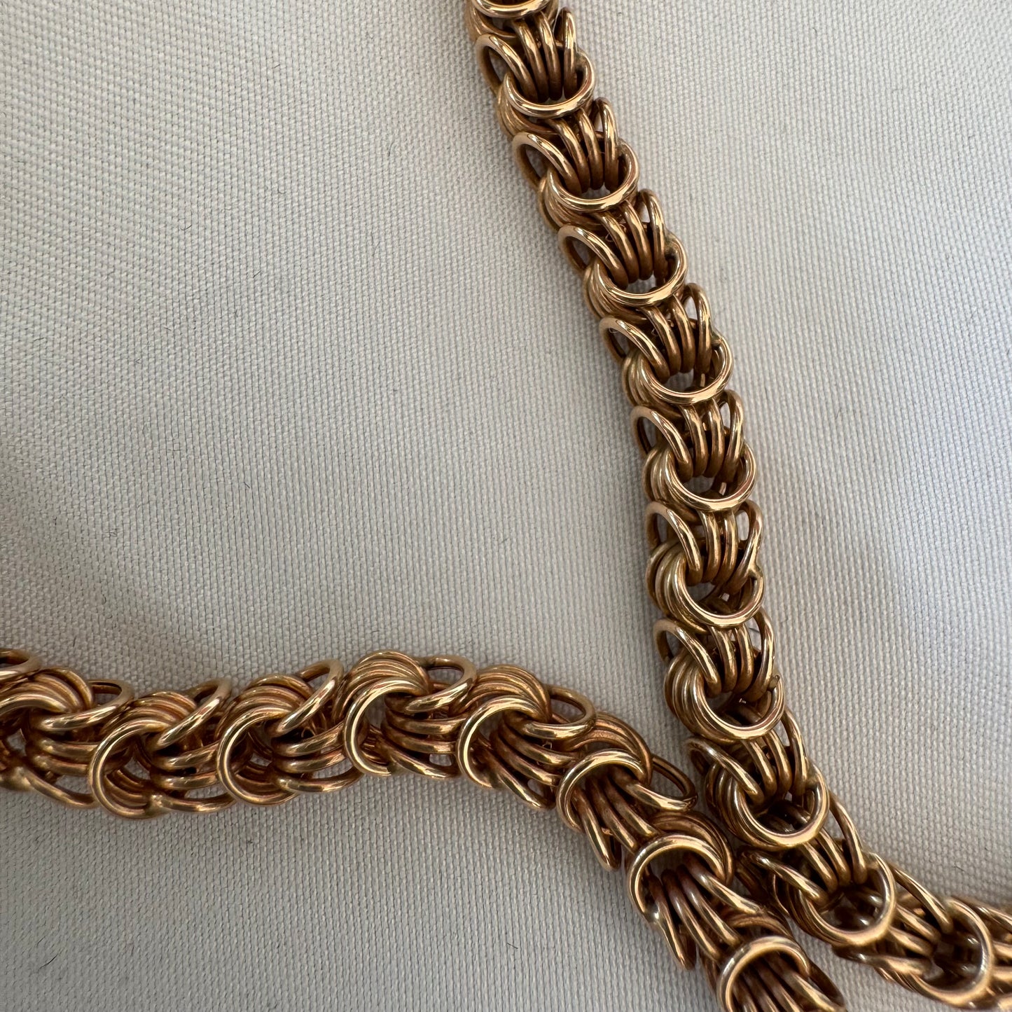 14K gold necklace featuring intricate, interwoven links that create a rich and textured look.