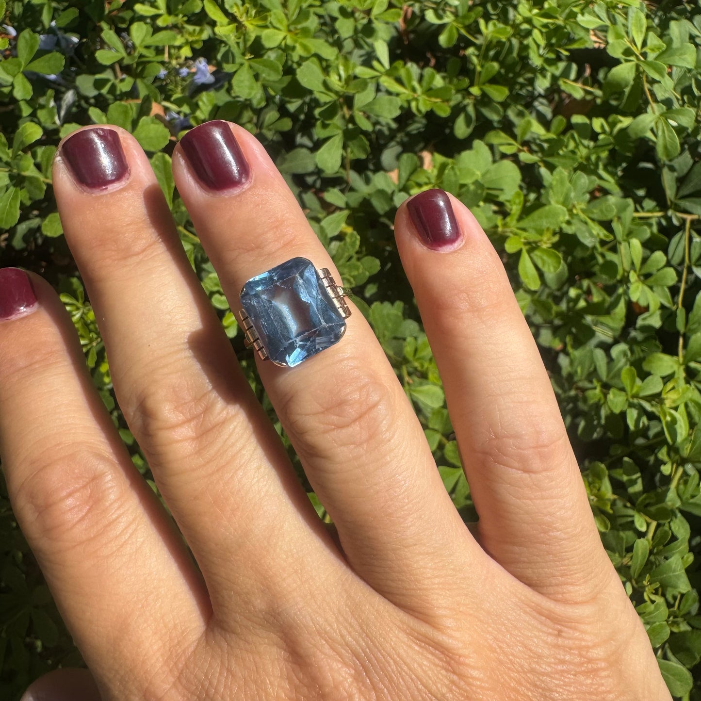 18K gold ring featuring a large rectangular Blue Topaz in a bezel setting with decorative side details.