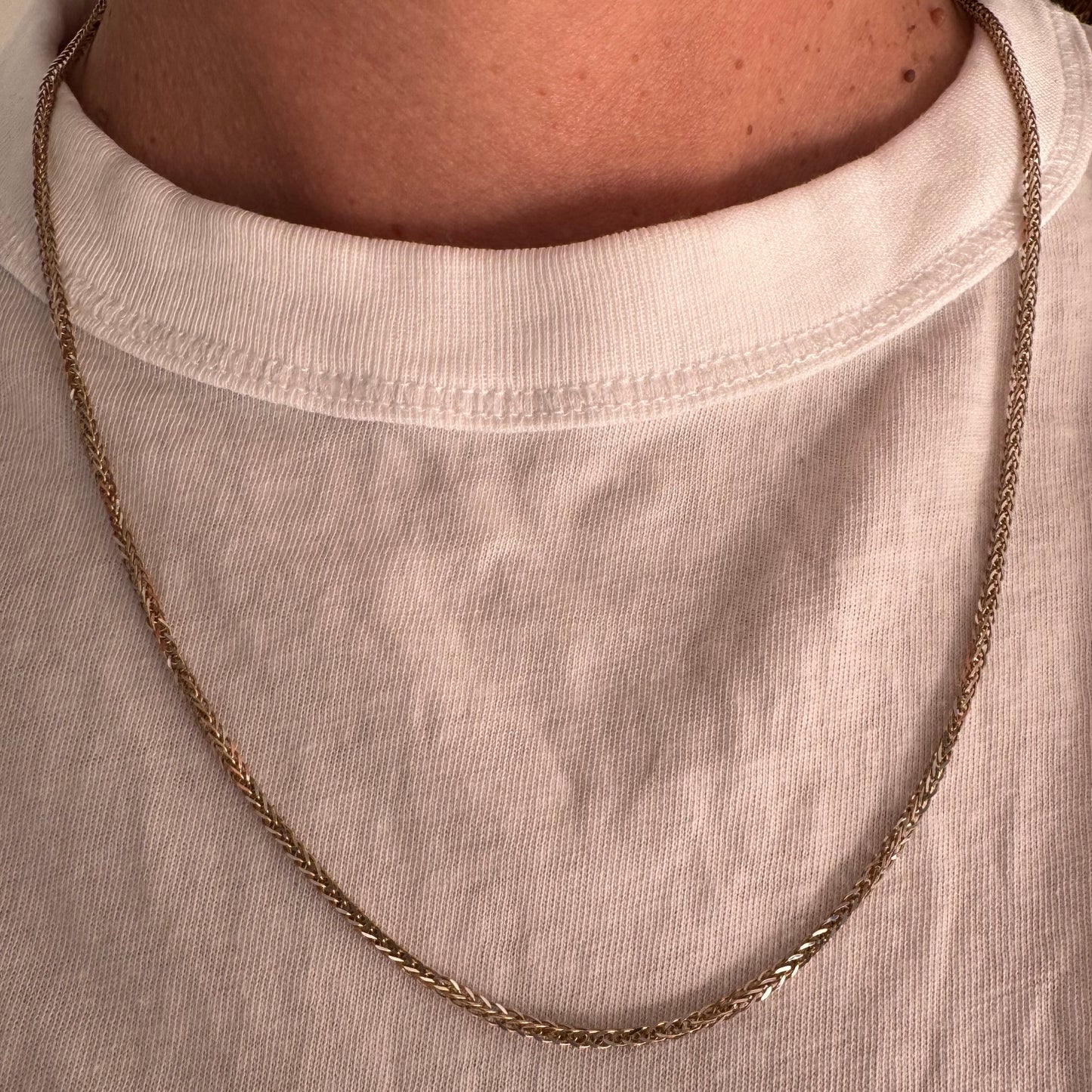 שרשרת זהב צהוב 14 קראט בעיצוב חוליות קלועות היוצרות מראה עשיר ומלא ברק.