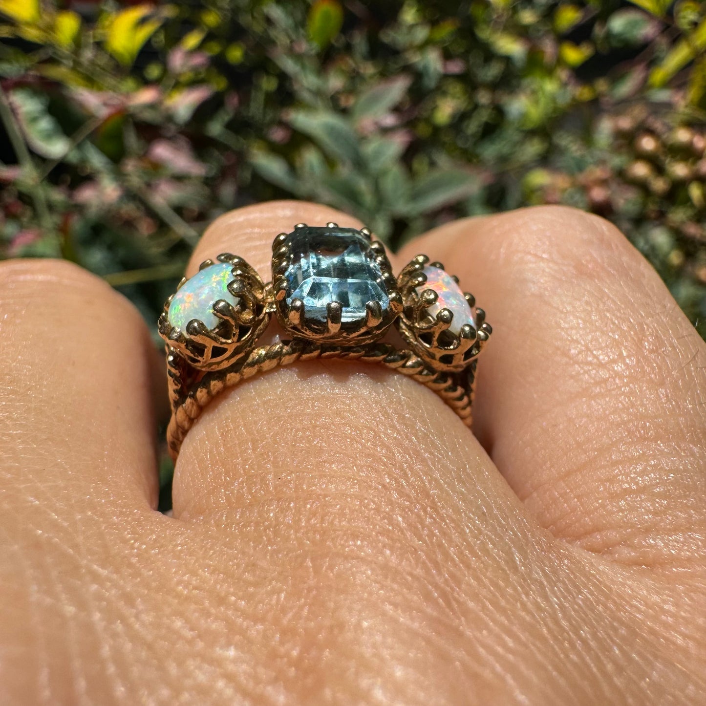 10K gold ring set with a light blue Aquamarine flanked by two dreamy Opals