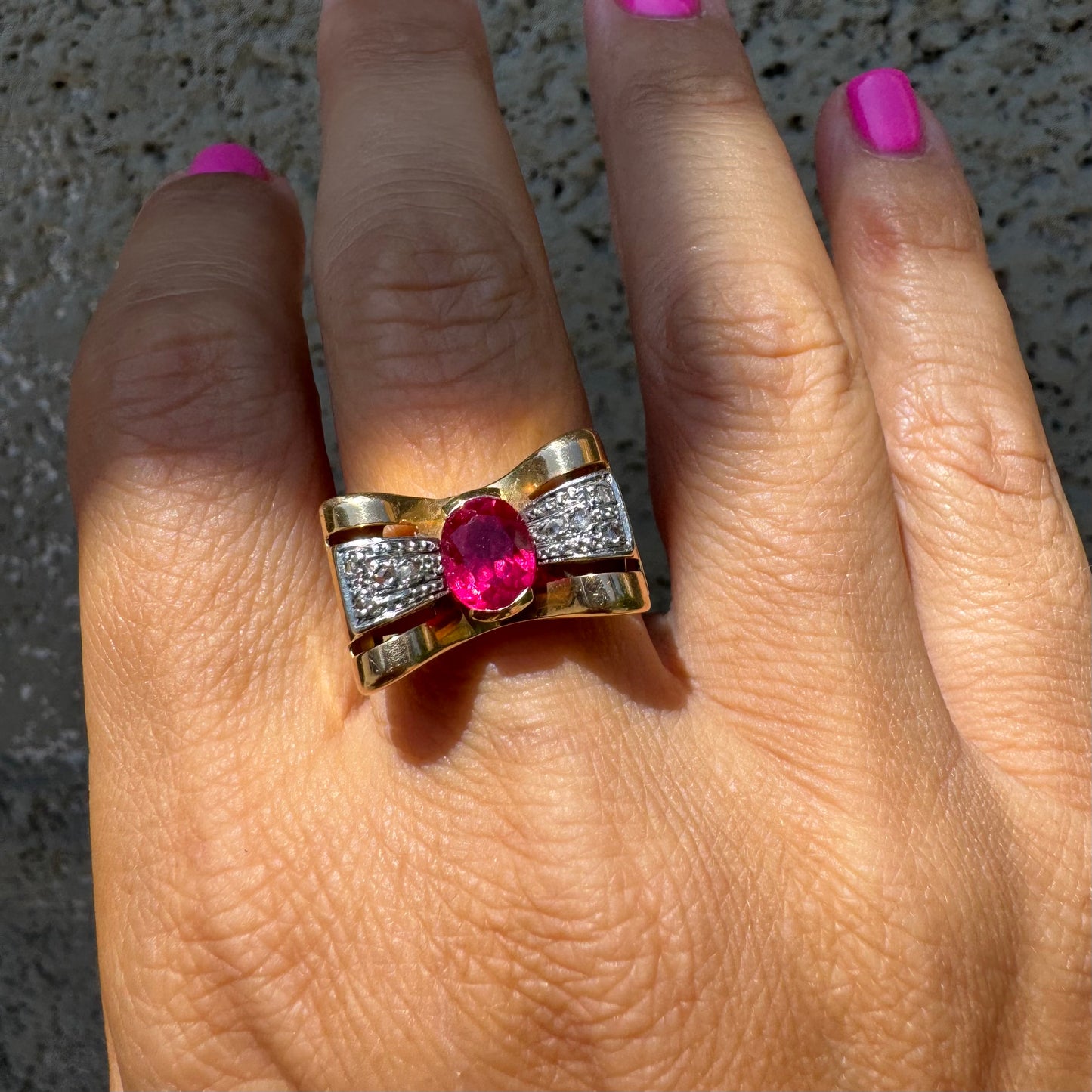 18K gold ring in a sculptural bow-inspired design.
Set with a vivid oval-cut Ruby at the center, framed by shimmering Diamonds