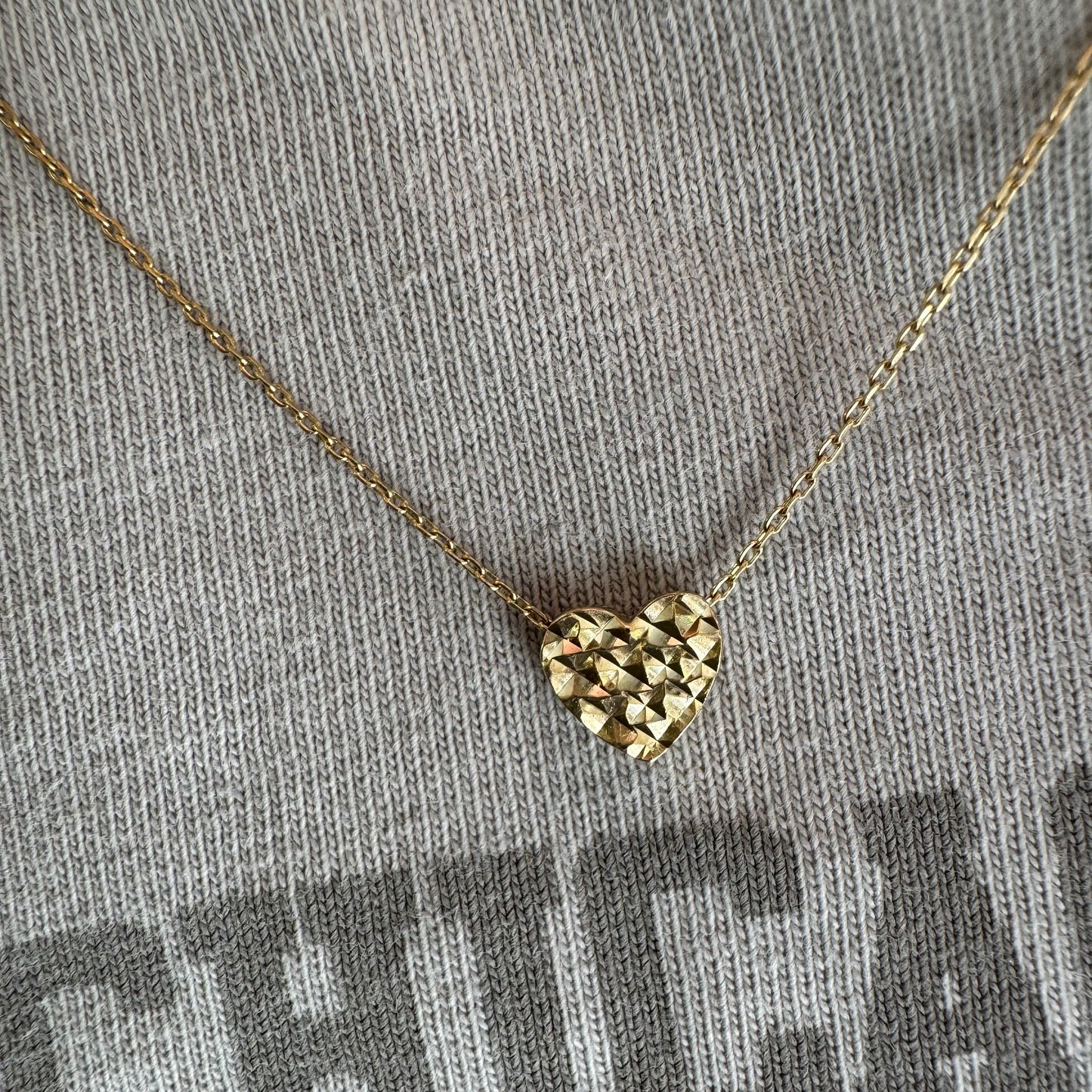 14K gold necklace featuring a heart-shaped pendant with a delicate geometric texture