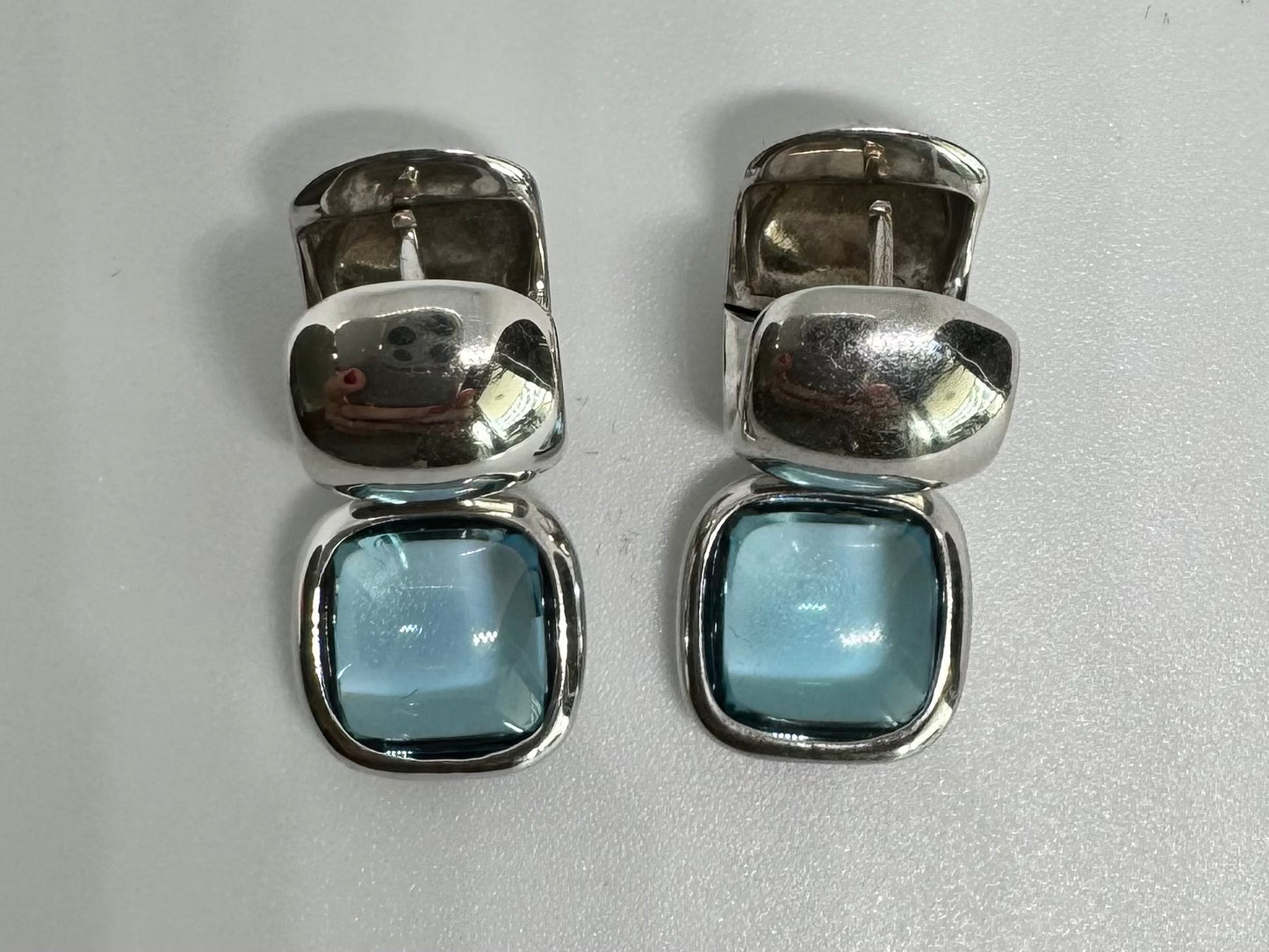 18K gold drop earrings featuring cushion-shaped Aquamarine in a smooth bezel setting, with a polished, modern design.