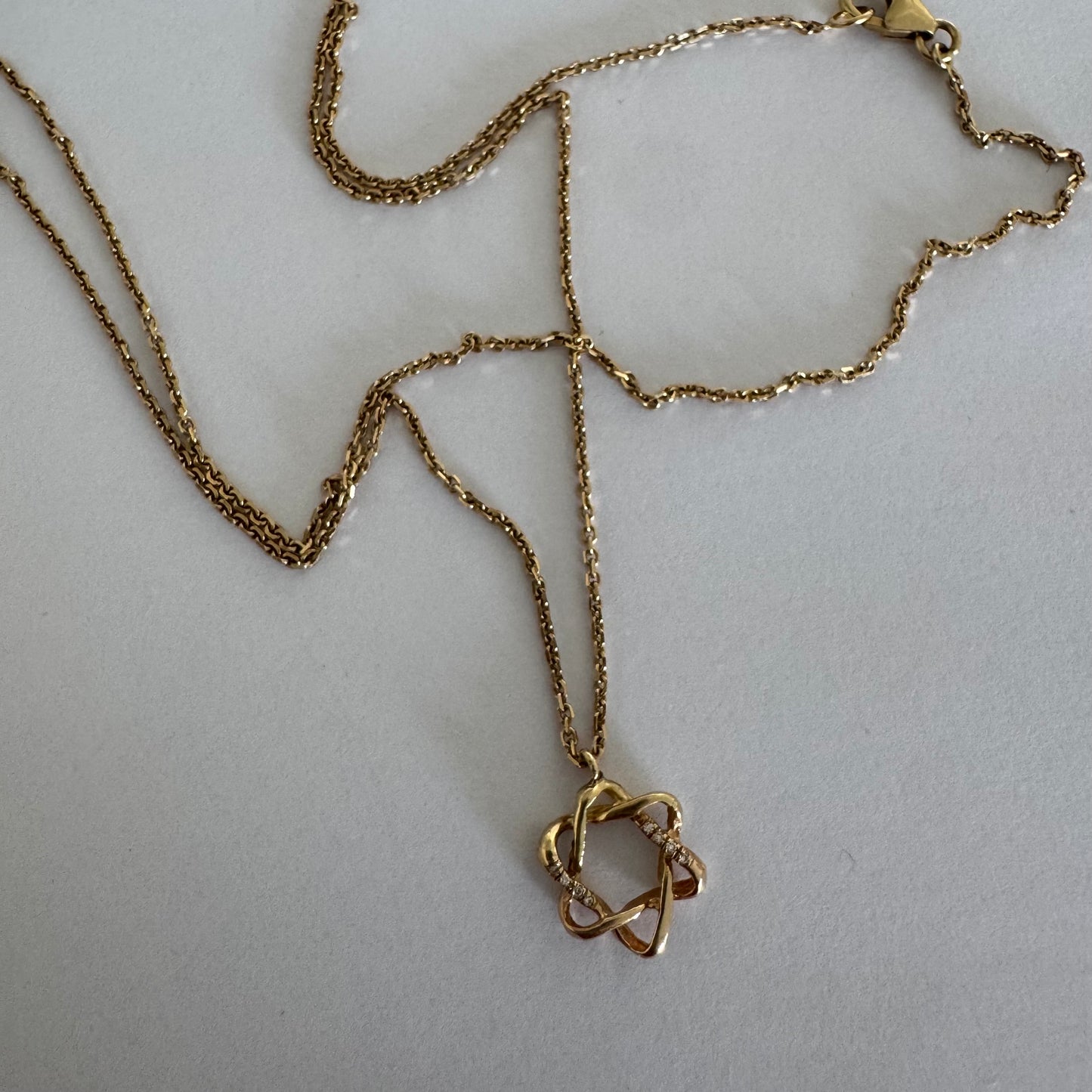 14K gold “Star of David” pendant with a sculptural open design.