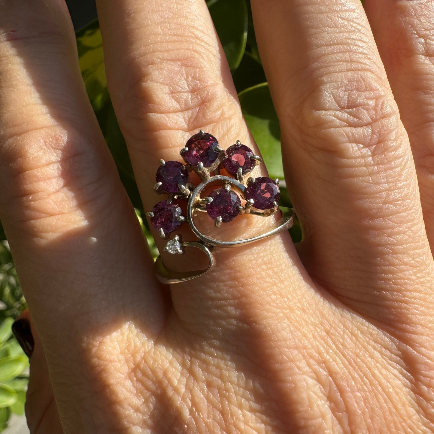 14K gold ring with an open, flowing design, set with multiple pink Tourmaline stones and accented by a Diamond