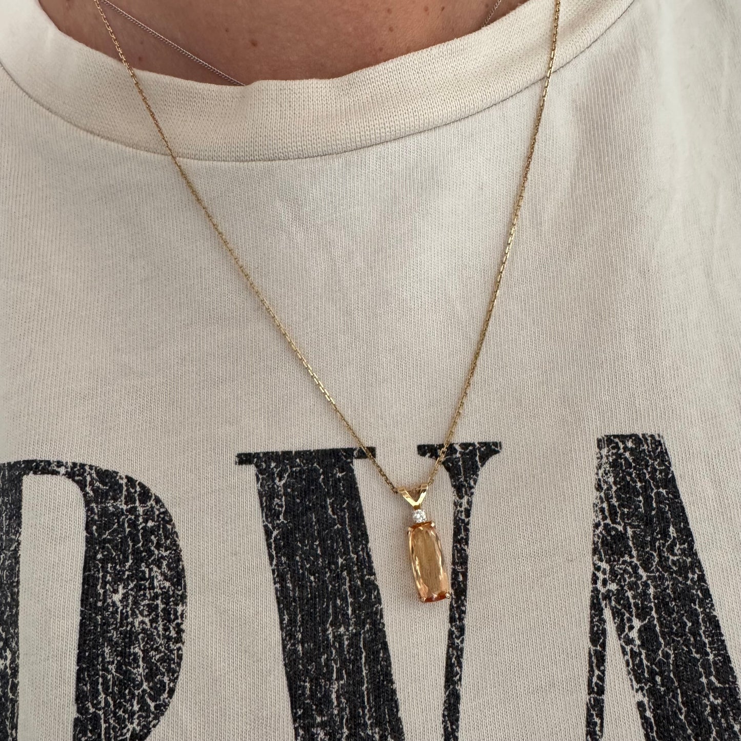 שרשרת זהב 14 קראט עם תליון זהב 14 קראט משובץ אבן קוורץ מלבנית בגוון שמפניה חמים, ומעליה יהלום נוצץ להדגשה עדינה של הברק.