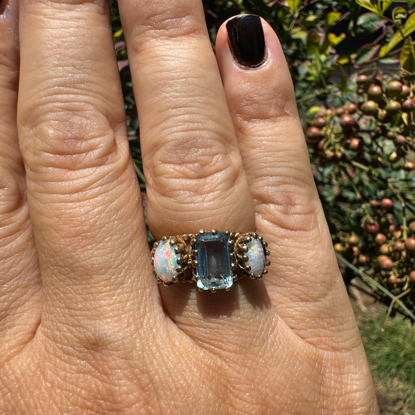 10K gold ring set with a light blue Aquamarine flanked by two dreamy Opals