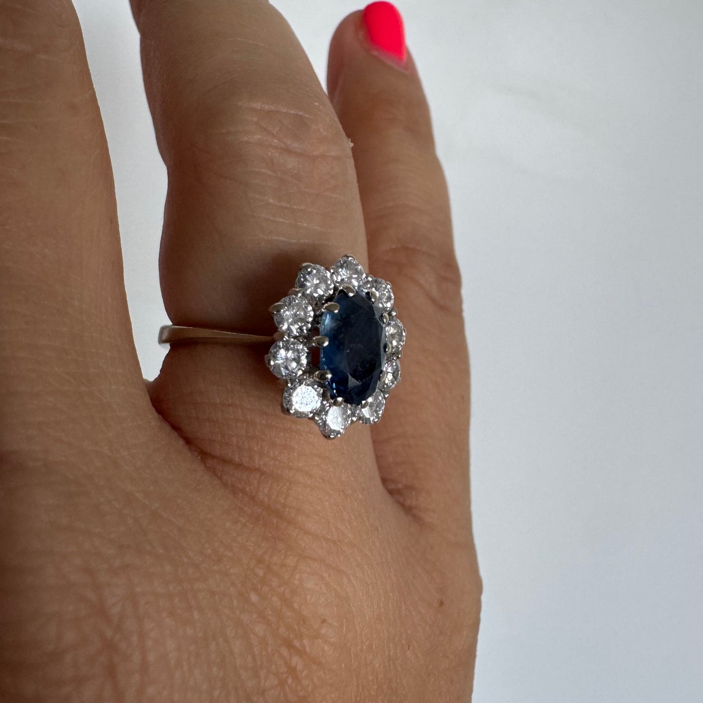 18K gold ring featuring a deep blue Sapphire at its center, surrounded by a sparkling halo of Diamonds