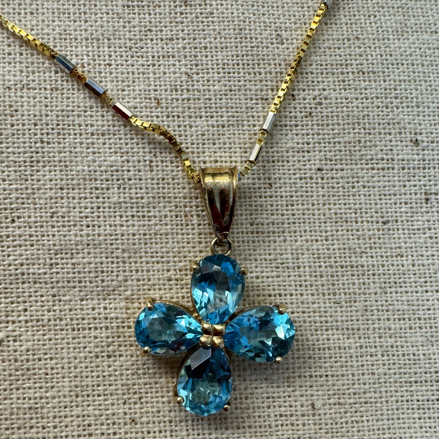 14K gold necklace with a cheerful floral pendant crafted from four pear-shaped Blue Topaz gemstones, arranged in a radiant blossom design