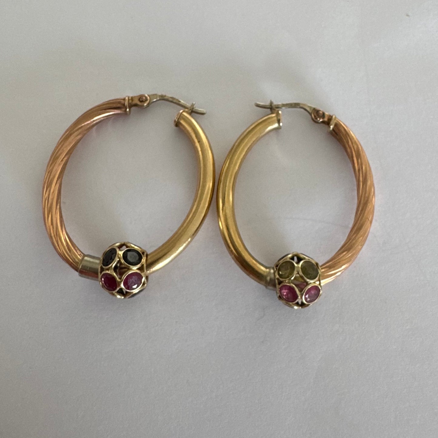 10K gold hoop earrings with a twisted design, set with pink and green Tourmaline.