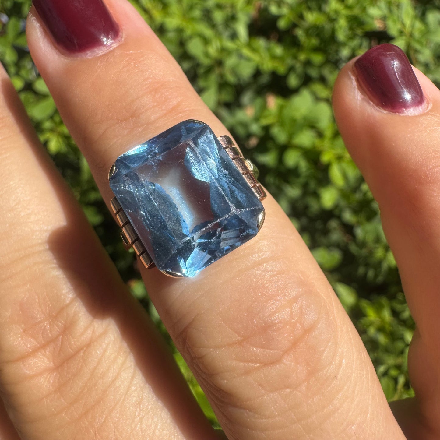 18K gold ring featuring a large rectangular Blue Topaz in a bezel setting with decorative side details.