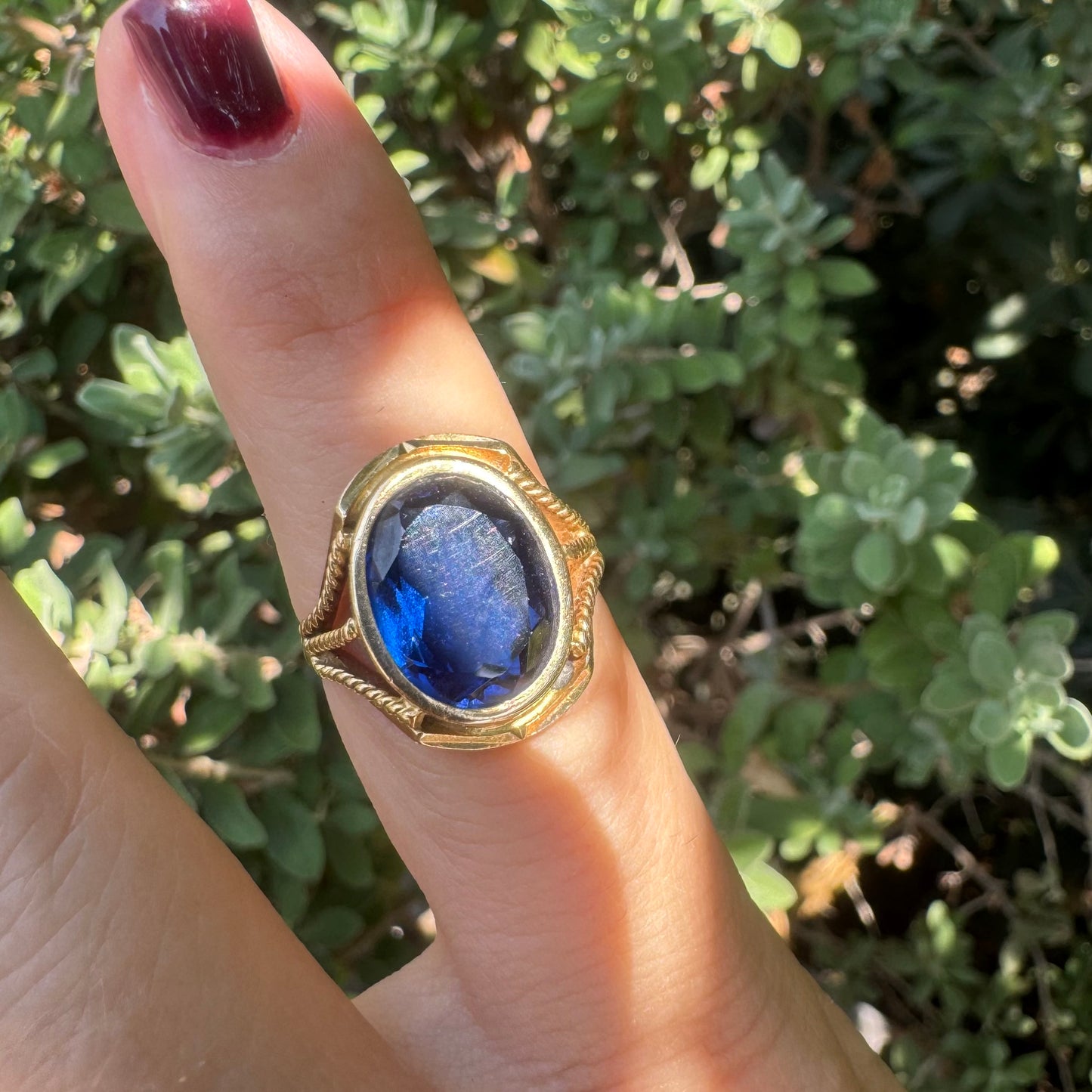 18K yellow gold ring set with a large oval deep blue Sapphire set in an ornate bezel.