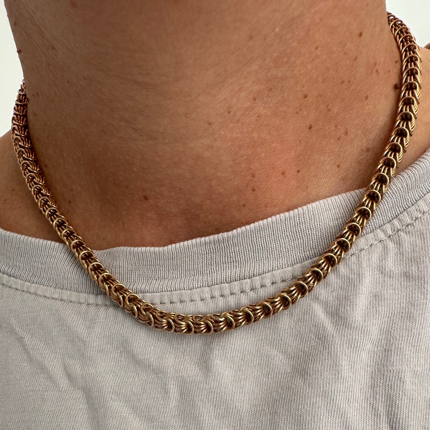 14K gold necklace featuring intricate, interwoven links that create a rich and textured look.