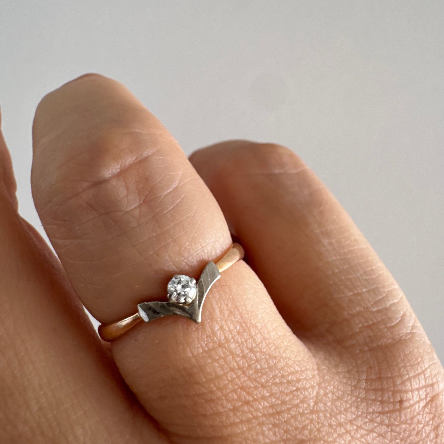 טבעת זהב 14 קראט עם ראש בצורת V מזהב לבן המשובץ יהלום עגול אחד.