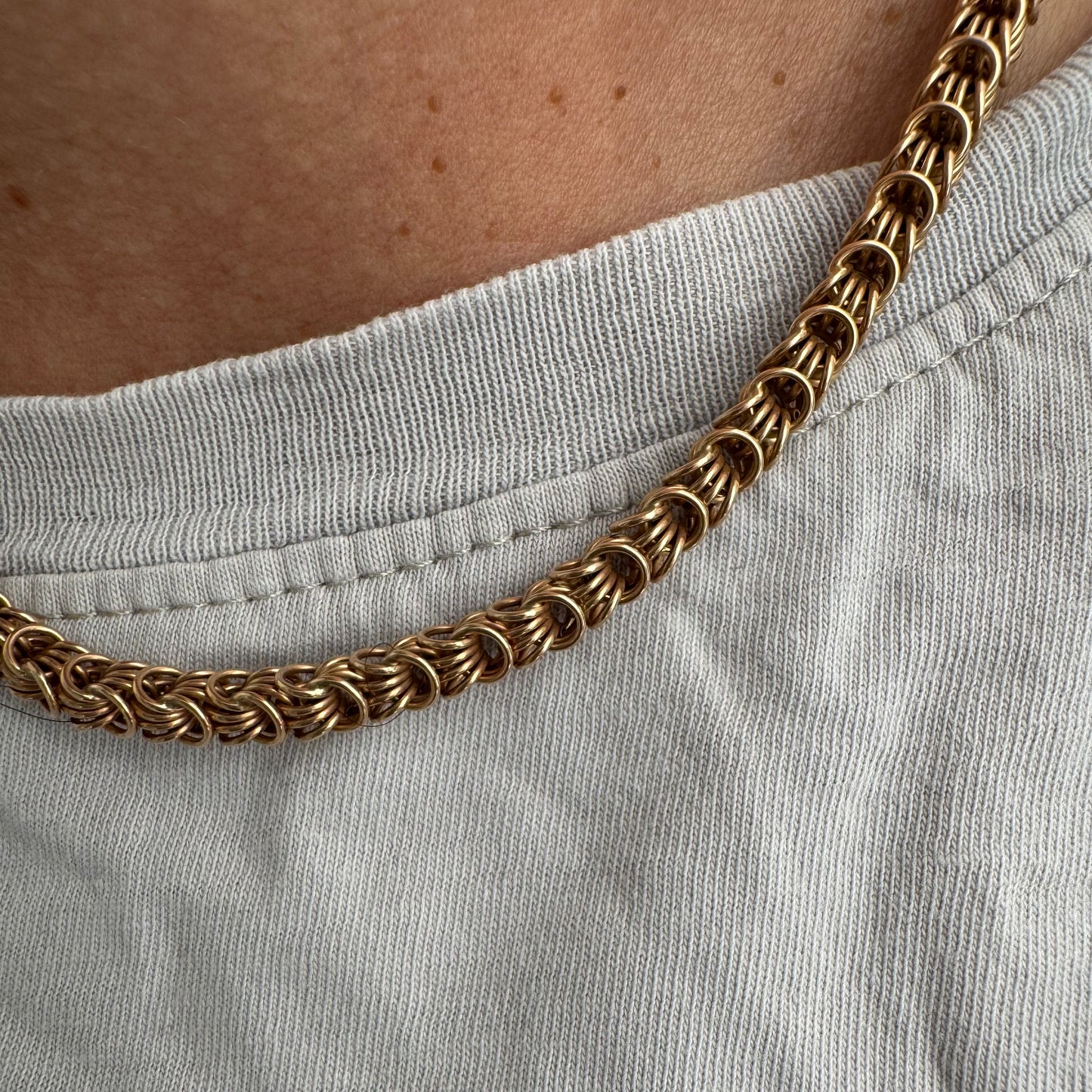 14K gold necklace featuring intricate, interwoven links that create a rich and textured look.
