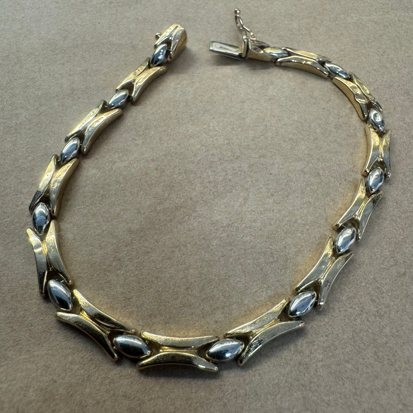 צמיד זהב צהוב וזהב לבן 14 קראט בעיצוב גאומטרי מיוחד, עם חיבורים בצורת X מזהב צהוב ושיבוצים מבריקים בזהב לבן