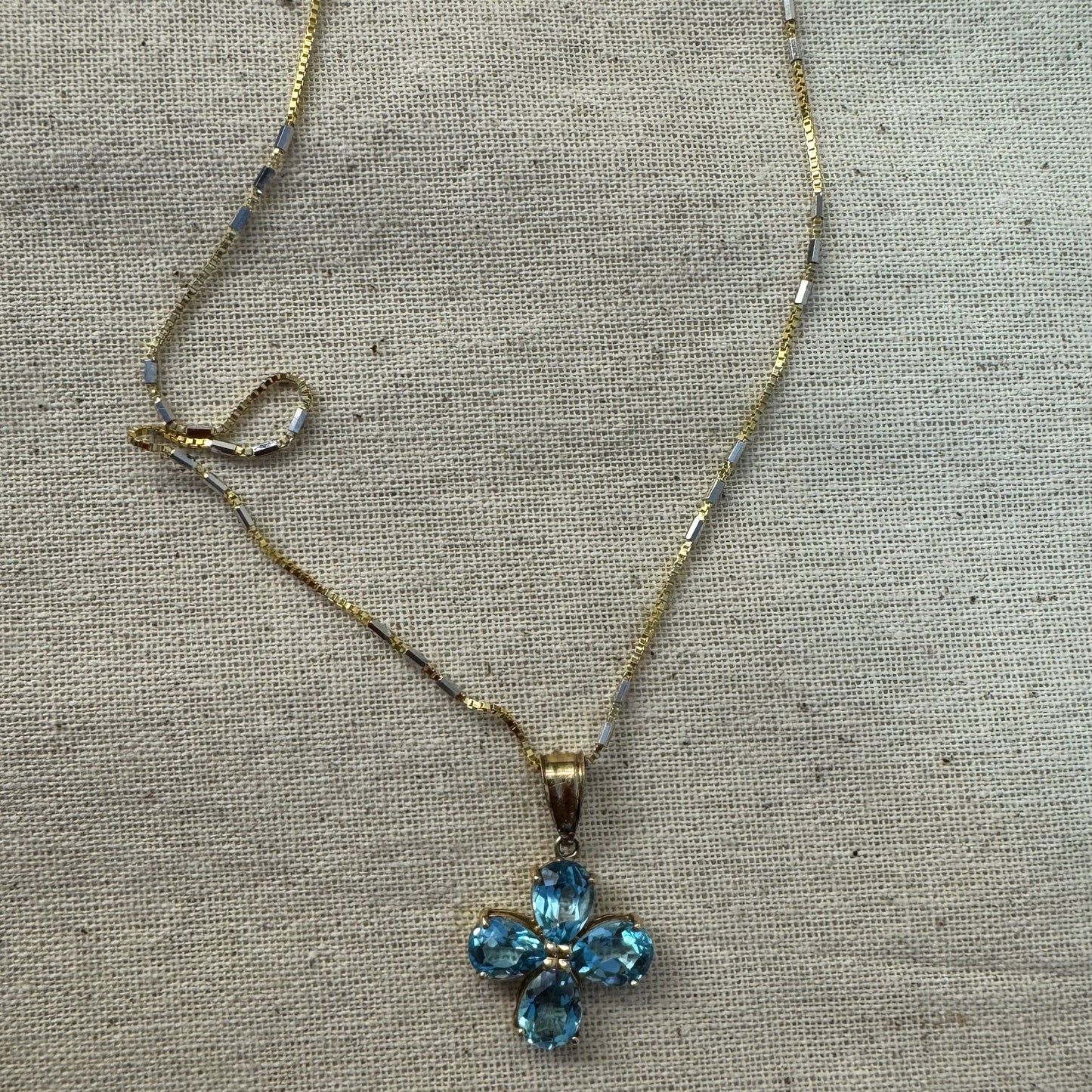 14K gold necklace with a cheerful floral pendant crafted from four pear-shaped Blue Topaz gemstones, arranged in a radiant blossom design